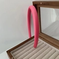 Dettaglio ravvicinato di una fascia per capelli imbottita in tessuto rosa in un portagioie - Tessuto a Costine Rosso