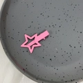 Pinza para el cabello con forma de estrella rosa pastel sobre un plato de cerámica gris - Rosa