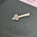 Détail d'une pince à cheveux dorée avec perles blanches et fleur séchée en résine rose - Style A