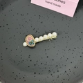Détail d'une barrette en perles faite main avec petite fleur bleue et médaillon rose - Style C