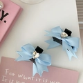 Detailweergave van twee lichtblauwe satijnen strik haarklemmen met hart-strass - Blauw