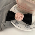 Rosa Satinrose auf schwarzer Stoffschleife Haarklammer auf einem eleganten Keramikteller - Federclips