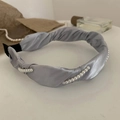 Détail d'un serre-tête en satin gris clair avec perles blanches et texture de tissu torsadé - Bleu