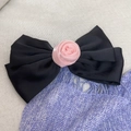 Gros plan sur le nœud papillon en satin noir élégant avec une rose en tissu rose délicate - Clips à ressort