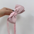 Detail einer rosa Seidenschleifen-Haarklammer mit langen, eleganten Bändern - Rosa