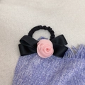 Gros plan détaillé d'une rose en satin rose et d'un nœud noir sur un élastique à cheveux - Élastique à cheveux