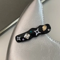 Primer plano de pinza de pelo negra ondulada con pedrería brillante y detalles de estrellas - Onda Negro