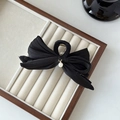 Detail einer eleganten schwarzen Haarklammer mit Satinschleife und kleiner Perle - Schwarz