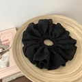 Close-up of black floral bubble chiffon scrunchie on a wooden tray with elegant props - Black