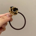 Close-up of a floral acrylic hair tie with a brown tortoiseshell rose pattern decoration - Light Leopard