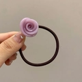 Detail of a purple resin rose hair tie held by hand against a clean light background - Purple