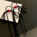 Dettaglio di elastici per capelli con rosa rossa e lunghi nastri in raso nero - Elastico per capelli