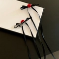 Dettaglio di fermagli per capelli con fiocco in raso nero, rose rosse e nastri lunghi - Fermaglio per capelli