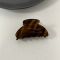 Detailed close-up of tortoise shell acetate hair claw clip with golden branding text - Brown