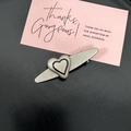 Matte silver alloy hair clip with black-bordered heart on black background with card - Oval Sacred Heart Pendant