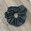 Detail eines großen dunkelgrauen Denim-Haargummis mit weißen Punktmustern auf Holz - Haargummi / Schwarzes Haargummi
