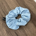 Detailansicht eines hellblauen Denim-Haargummis mit silbernen Strassherzen auf Holzgrund - Haargummi / Hellblaues Haargummi