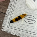 Close-up of tortoise shell pattern acetate hair clip on a white woven background - Dark Leopard Print