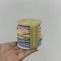 Détail macro d'un ensemble d'élastiques à cheveux multicolores pastel sur bobine blanche - Couleurs Claires