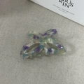 Dettaglio molletta a farfalla in acetato con texture marmorizzata e molla in metallo - Viola