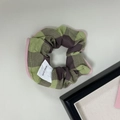 Dettaglio di elastico scozzolo a scacchi verde oliva con bordo rosa ed etichetta fatta a mano - Verde