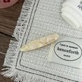 Detail view of oval tortoise shell hair clip with France engraving on woven fabric - Beige Pattern