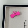 Nahaufnahme der pinkfarbenen Schleifen-Haarspange mit Perlenkrone in einer Box - Rosenrot