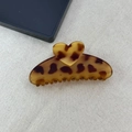 Detail view of large leopard heart claw clip with amber pattern on a grey fabric background - Matte Half-round Style