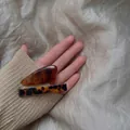 Gros plan de barrettes élégantes en acétate ambre et écaille sur tissu en soie douce - Série Ambre