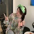 Cerchietto alla moda con maxi fiocco in tessuto verde lime per donna in un caffè chic - Verde