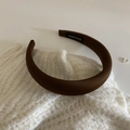 Detail of brown satin padded headband with smooth texture and handmade woven label - Dark Brown