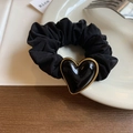 Detalle de un coletero negro con un dije en forma de corazón negro con borde dorado - Corazón Negro
