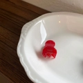 Mini red acrylic hair claw clip with golden France Handmade logo in a white porcelain bowl - Red