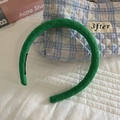 Dettaglio della fascia per capelli in tessuto verde con elegante trama a rombi trapuntati - Verde