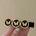 Detail of vintage black hair clip featuring gold butterfly metal charms on fabric base - Black