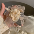 Detailed close-up of handmade beige organza flower hair claw with woven label - Champagne