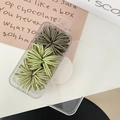 Set of dark and light green elastic hair bands in a clear storage box on a desk - Green