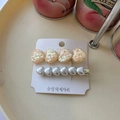 Detail view of heart-shaped sequins and pearl hair clips set on a display card - Yellow