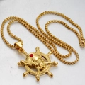 Close-up of golden pirate skull pendant with red gemstone on a vintage ship wheel - Gold Pirate Skull Rudder