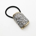 Close-up of golden U-shaped hair tie with sparkling rhinestones and black elastic band - Gold
