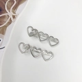 Set di due fermagli per capelli in metallo lucido argento con cuori traforati - Argento