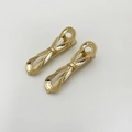 Detail goldener Legierungsklammern mit hohlem Twist-Design und strukturierter Oberfläche - Gold