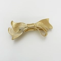 Detailed view of golden metal bow hair clip with elegant wave texture and spring closure - Ribbon Bow Style (Gold)