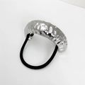 Macro view of wide silver hammered metal cuff hair tie with high elastic black band - Silver
