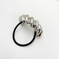 Detailansicht eines schwarzen elastischen Haargummis mit gedrehtem Silbermetallelement - Silber