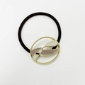 Detailed macro view of the gold-tone gear-shaped metal charm with enamel inlay on a black elastic band - Round Enamel Taro White Gold