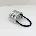 Detailed view of silver U-shaped metal ponytail holder with wavy texture and black elastic - Silver