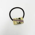 Detailed close-up of golden metal hair tie with purple enamel on black elastic band - Square Enamel Taro Gold
