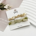 Detail of elegant pearl hair clips and green resin barrettes on display card - Green