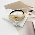 Detalle de coletero dorado con un colgante de estrella blanca con brillo de perla - Estilo de Colgante de Pentagrama / Fila Única Dorado